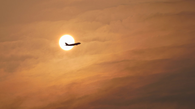 飞机飞过太阳黄昏夕阳