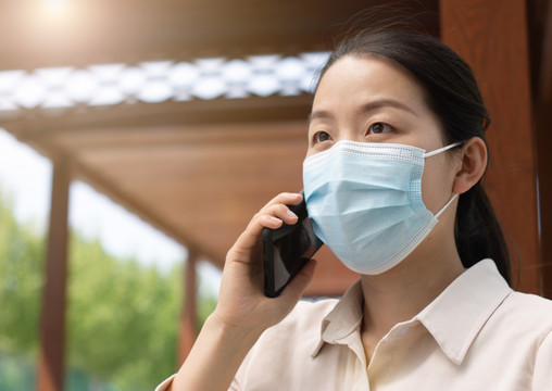 中国女性戴口罩户外办公打电话