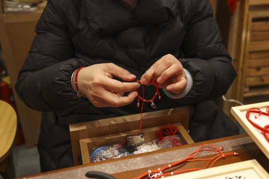 手工艺匠人在编织中国结手环