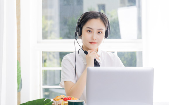 戴耳麦的女学生在电脑前上课