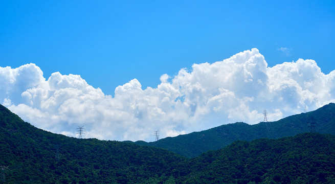 夏日蓝天白云山上电线塔