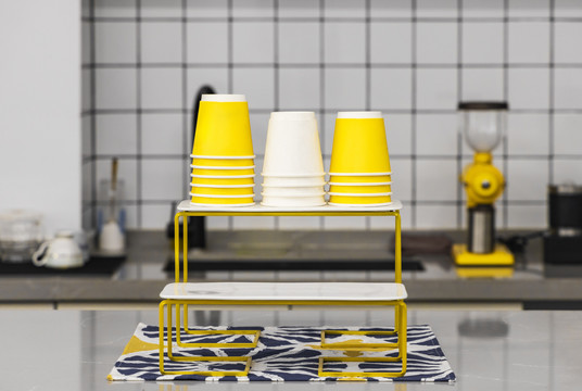 台子上的黄色和白色一次性纸杯