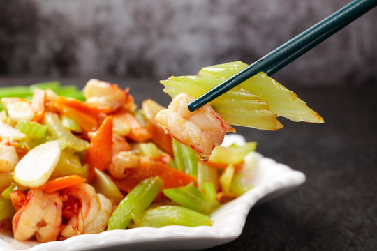 筷子上夹着芹菜炒虾仁