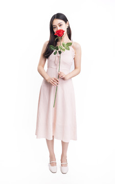 穿粉色连衣裙拿着一朵花的女人