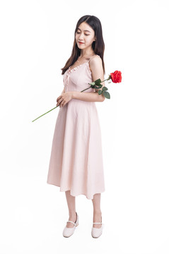穿粉色连衣裙拿着一朵花的女人