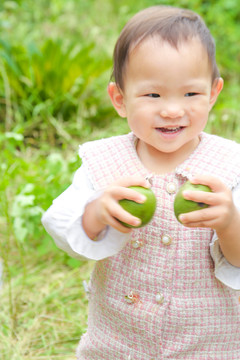 小孩手里拿着青核桃