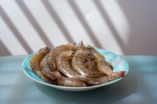 白色背景前盘子里的新鲜海虾