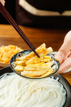 筷子夹着碟子里的酸笋