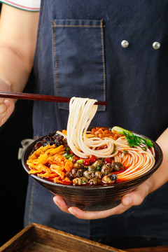 筷子上夹着碗里的螺蛳粉