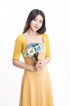 穿黄色连衣裙拿着一束花的女人
