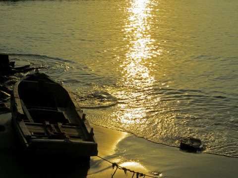 夕阳下海滩边的木头船