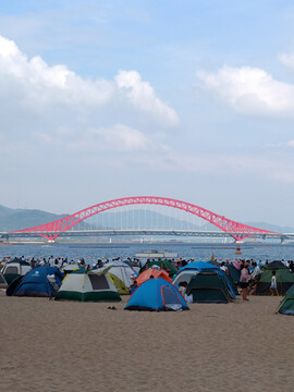 蓝天红桥海边沙滩露营