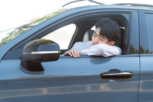 趴在车窗的年轻男性司机