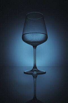 蓝色背景下盛有液体的酒杯