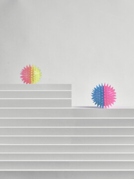 白色阶梯上的两个玩具彩色小球