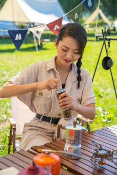 女孩坐天幕下研磨咖啡