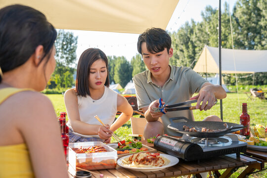 一群人坐天幕下烧烤