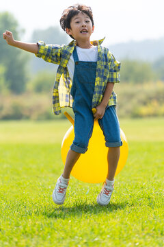 一个小男孩在草地上玩球