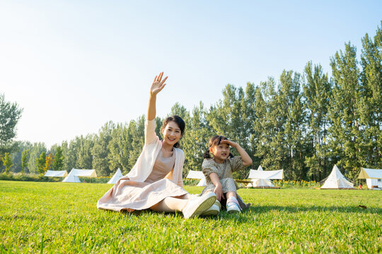 妈妈和女儿在草地上做打招呼