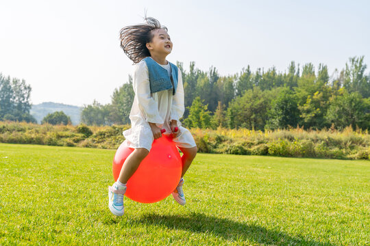 一个小女孩在草地上玩球