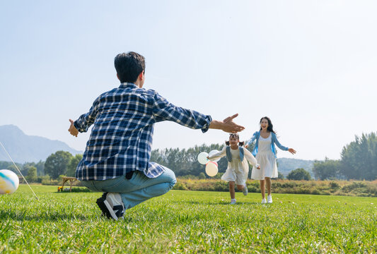 妈妈和女儿开心地跑向爸爸的怀抱