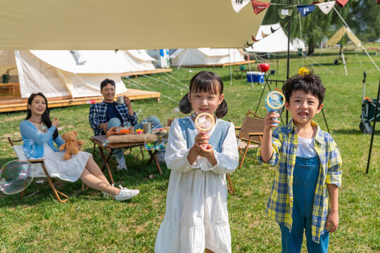 一家人在露营地天幕下玩耍