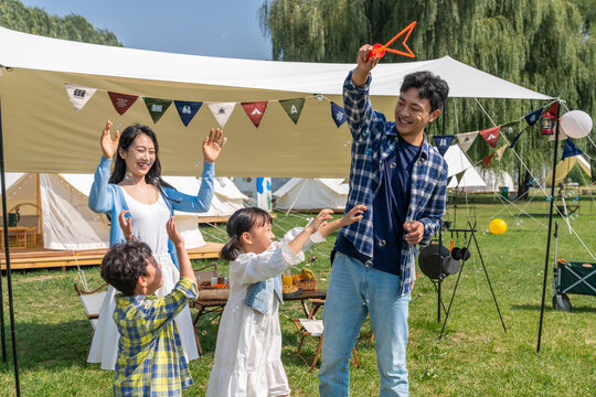 一家人在露营地天幕下玩耍