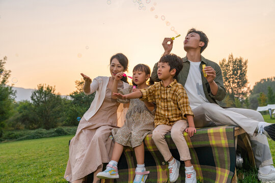 一家人在夕阳下吹泡泡