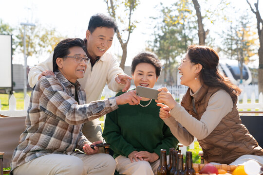 一群中老年人在房车露营地看手机视频