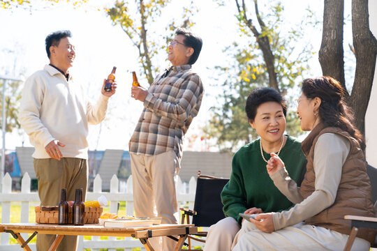 一群中老年人房车露营地喝啤酒聊天看视频