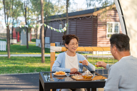 中老年夫妻在露营地喝茶聊天