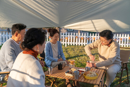 一群中老年人露营地喝咖啡聊天