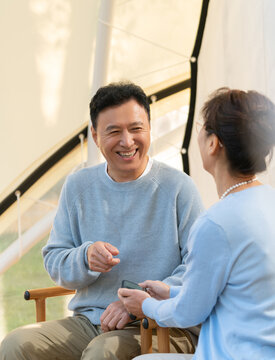 老年夫妻在露营地坐着摇椅聊天