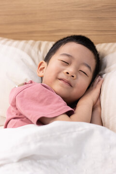 一个小男孩躺在舒适的床上睡觉