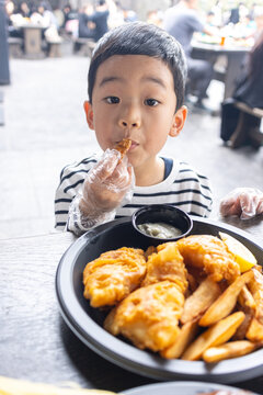 小男孩满足地吃炸鸡薯条