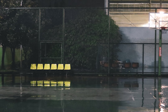 下雨天篮球场上的黄色座椅