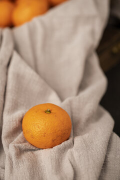灰色麻布上的一颗橘子柑橘