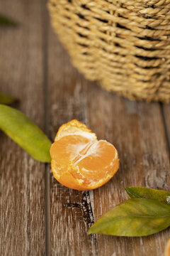 木桌上一个掰开的橘子