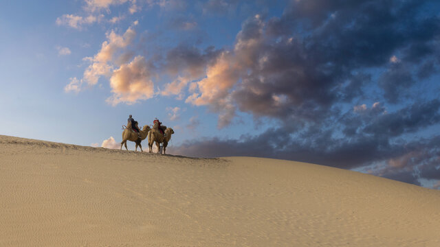 蓝天彩云衬托沙漠与骆驼