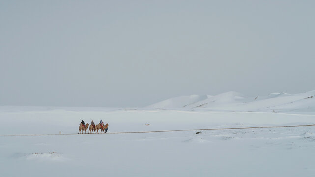 白雪覆盖的鸣沙山与旅人