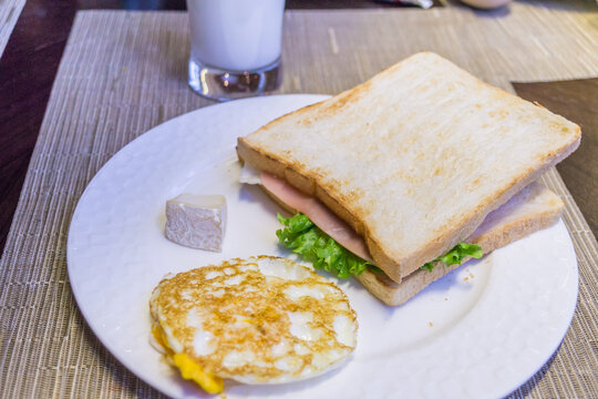 一盘煎蛋和火腿三明治早餐