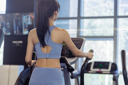 健身房使用跑步机的女性背影