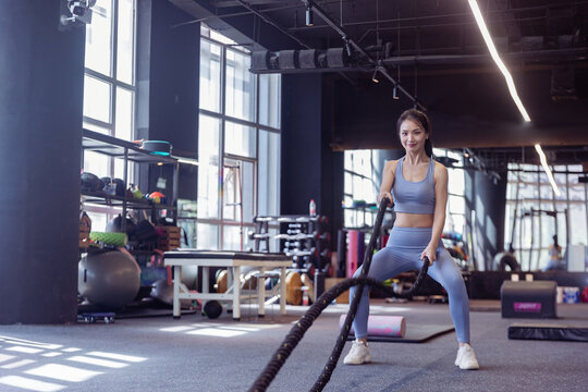 健身房使用格斗绳锻炼的女性