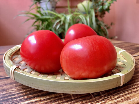 木纹桌子上竹篮竹筐里的西红柿