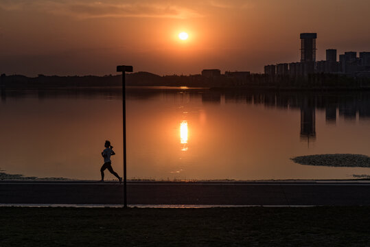 夕阳里成都兴隆湖边跑步的人