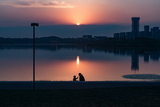 夕阳下公园湖边母女游戏