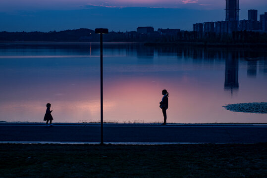 夕阳下公园湖边母女游戏