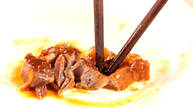 筷子夹起一块红酒牛肉