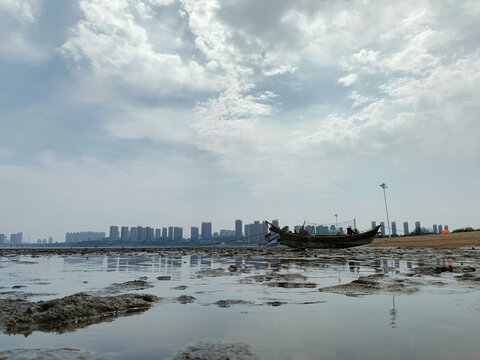 渔船海滩城市落潮阴天