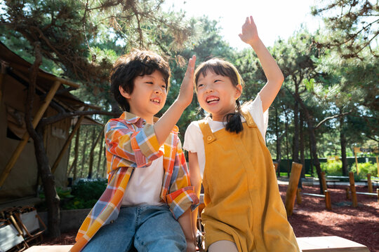 两个小孩子开心击掌庆祝